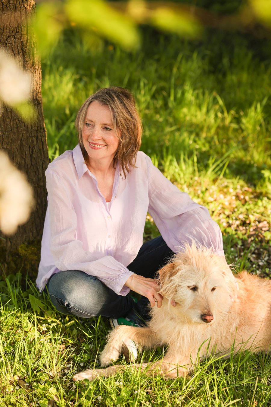 Ergotherapeutin Alexandra Rupp mit ihrem Therapiehund unter einem Baum